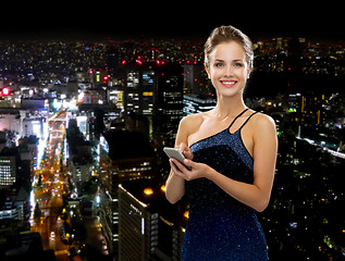 Image showing smiling woman in evening dress with smartphone
