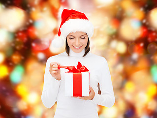 Image showing smiling woman in santa helper hat with gift box