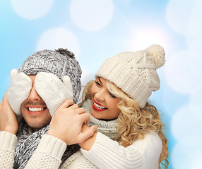 Image showing smiling couple in sweaters and santa helper hats