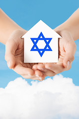 Image showing close up of hands holding house with star of david