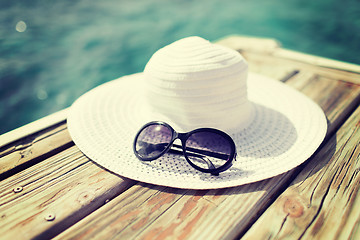 Image showing close up of hat and sunglasses at seaside