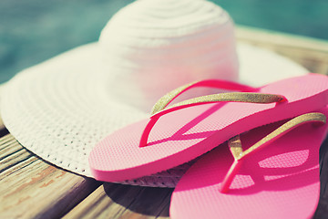 Image showing close up of hat and slippers at seaside