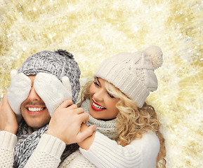 Image showing smiling couple in sweaters and santa helper hats