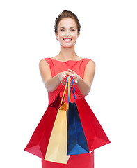Image showing smiling elegant woman in dress with shopping bags