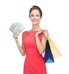 Image showing smiling elegant woman in dress with shopping bags