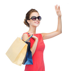 Image showing smiling elegant woman in dress with shopping bags