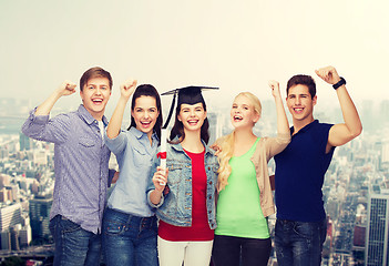 Image showing group of standing smiling students with diploma