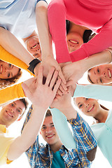 Image showing smiling teenagers with hands on top of each other