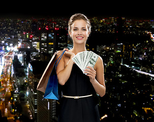 Image showing smiling woman in dress with shopping bags