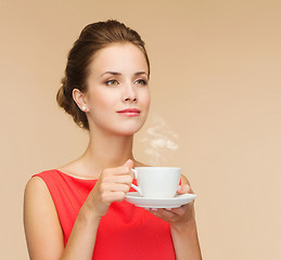 Image showing smiling woman in red dress with cup of coffee