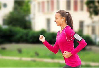 Image showing smiling young woman running outdoors