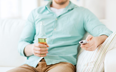 Image showing man with beer and remote control at home