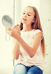 Image showing teenage girl with lip gloss and mirror