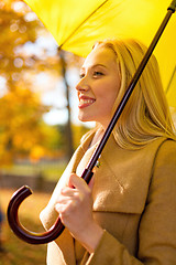 Image showing smiling woman with umbrella in autumn park