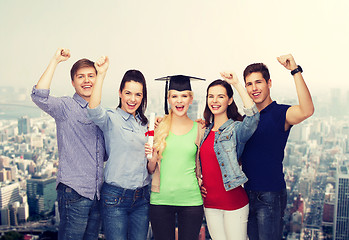 Image showing group of standing smiling students with diploma