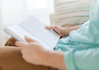 Image showing close up of man reading book at home