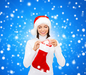 Image showing woman in santa hat with gift box and stocking