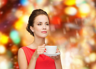 Image showing smiling woman in red dress with cup of coffee