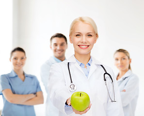Image showing smiling female doctor with green apple
