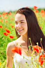 Image showing smiling young woman on poppy field