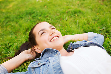 Image showing smiling young girl lying on grass