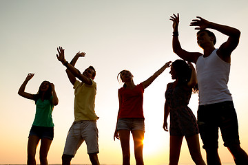 Image showing smiling friends dancing on summer beach