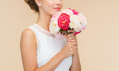 Image showing smiling woman in white dress with bouquet of roses