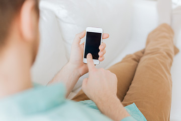 Image showing close up of man sitting with smartphone at home
