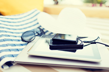 Image showing close up of tablet pc and smartphone on beach