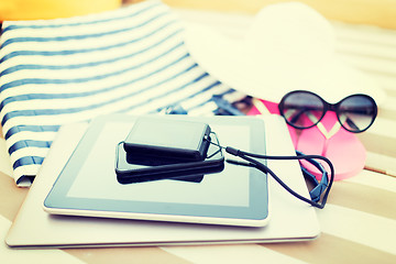 Image showing close up of tablet pc and smartphone on beach