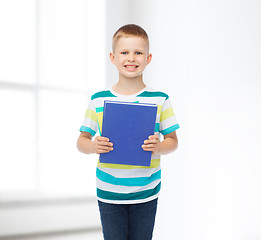 Image showing smiling little student boy with blue book