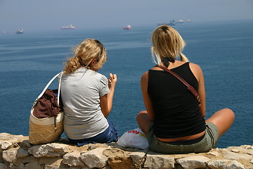 Image showing Two girls sitting by the sea