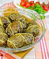 Image showing Rhubarb leaves stuffed in glass dish with tomatoes