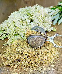 Image showing Herbal tea of meadowsweet in strainer on board