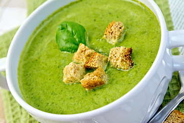 Image showing Soup puree with spinach leaves and croutons on napkin