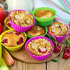 Image showing Cupcakes with rhubarb and cherries in tins on board