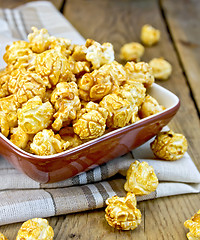 Image showing Popcorn caramel on board in clay bowl with napkin