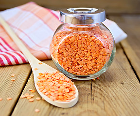 Image showing Lentils red in jar and spoon with napkin on board