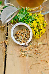 Image showing Herbal tea from tutsan in strainer with cup on board