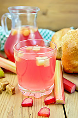 Image showing Compote from rhubarb in glass and jug with bread on board