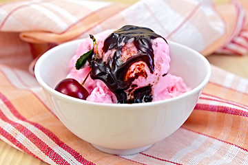 Image showing Ice cream cherry with chocolate syrup on napkin