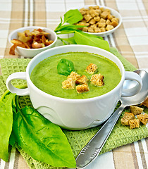 Image showing Soup puree with spinach and spoon on fabric