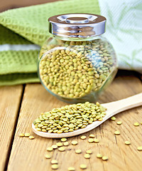 Image showing Lentils green in jar and spoon with napkin on board