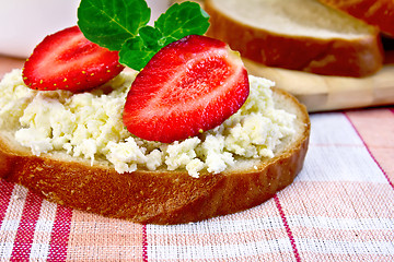 Image showing Bread with curd and strawberries on red fabric