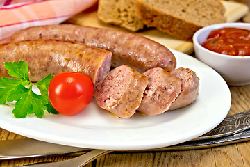 Image showing Sausages pork fried in plate on board with bread