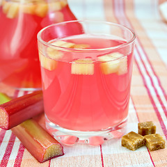 Image showing Compote from rhubarb in glass and pitcher on tablecloth