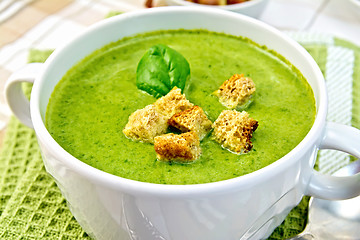 Image showing Soup puree with spinach leaves and spoon on napkin