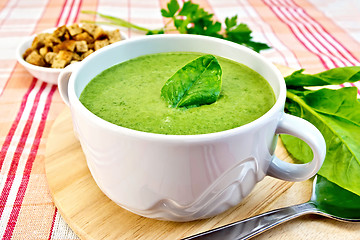 Image showing Soup puree with spinach leaves on fabric