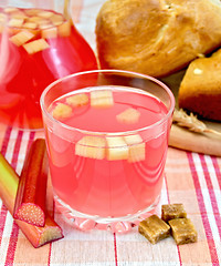 Image showing Compote from rhubarb in glass and jug on cloth with bread 