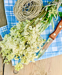 Image showing Meadowsweet fresh with knife and twine on board